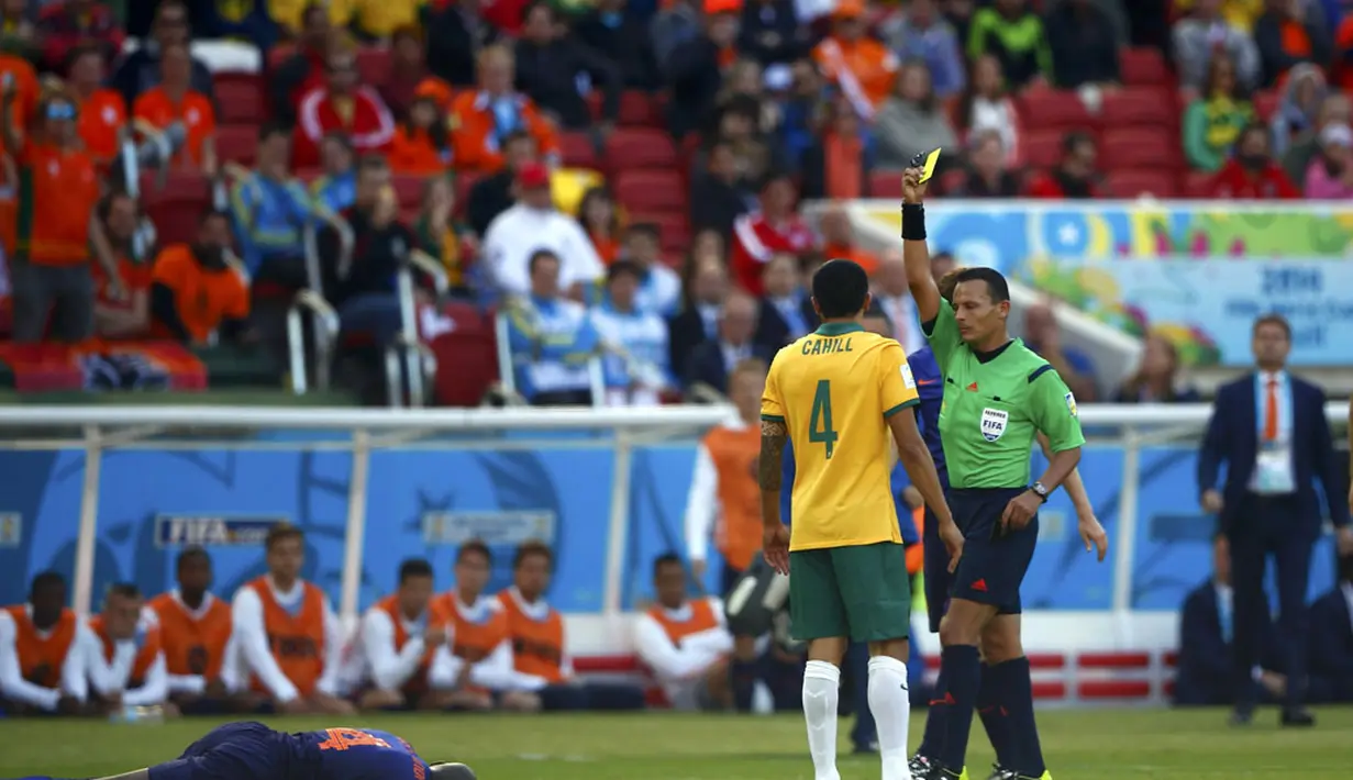 Tim Cahill (Australia - 4) diganjar kartu kuning akibat melakukan pelanggaran keras terhadap Bruno Martins Indi (tergeletak) di babak penyisihan Piala Dunia 2014 Grup B di Stadion Beira Rio, Porto Alegre, Brasil, (18/6/2014). (REUTERS/Darren Staples)