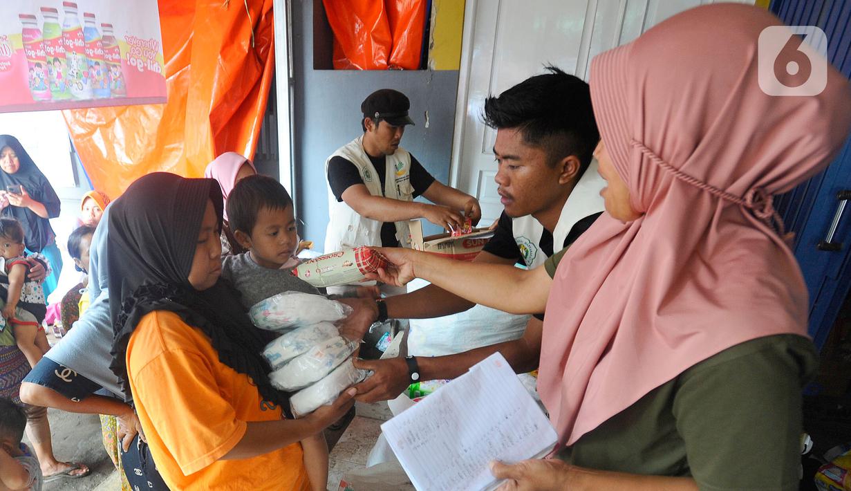 Warga antre mendapatkan pampers dan biskuit bagi anak-anak di Posko pengungsian Mangunkerta, Cianjur, Jumat (23/12/2022). Lebih dari sebulan sejak musibah gempa bumi 5,2 SR sejumlah warga masih tinggal di pengungsian dengan bantuan kebutuhan hidup dari para donatur. (merdeka.com/Arie Basuki)