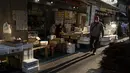 Seorang pria berjalan melalui jalan di daerah "pasar ikan luar" Tsukiji di Tokyo pada 28 Desember 2022. Menjelang liburan Tahun Bar, turis asing dan penduduk lokal berkunjung  ke pasar itu untuk menikmati hidangan bermacam makanan laut. (AFP/Richard A. Brooks)