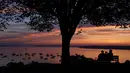 Pasangan menikmati teluk Casco saat matahari di Portland, Maine (21/8/2019). Casco Bay adalah saluran masuk Teluk Maine di pantai selatan Maine, New England, Amerika Serikat. (AP Photo/Robert F. Bukaty)