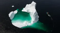 Kapal Kapten Edward Kean melewati gunung es terapung di Teluk Bonavista, Newfoundland, Kanada, 29 Juni 2019. Banyaknya gunung es terapung menjadikan Newfoundland destinasi wisata baru di Kanada. (Johannes Eisele/AFP)