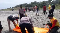 Para petugas gabungan BPBD, Basarnas, Poloairud Polres Garut, Jawa Barat tengah membawa salah satu jenazah pengunjung yang tenggelam di pantai selatan Garut. (Liputan6.com/Jayadi Supriadin)
