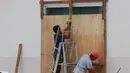 Para pekerja melapisi jendela dengan papan saat Badai Delta mendekati Puerto Morelos, Negara Bagian Quintana Roo, Meksiko, 6 Oktober 2020. Badai Delta diperkirakan akan melanda Negara Bagian Quintana Roo dengan hujan lebat, angin kencang, dan gelombang setinggi 10 meter. (Xinhua/Israel Rosas)