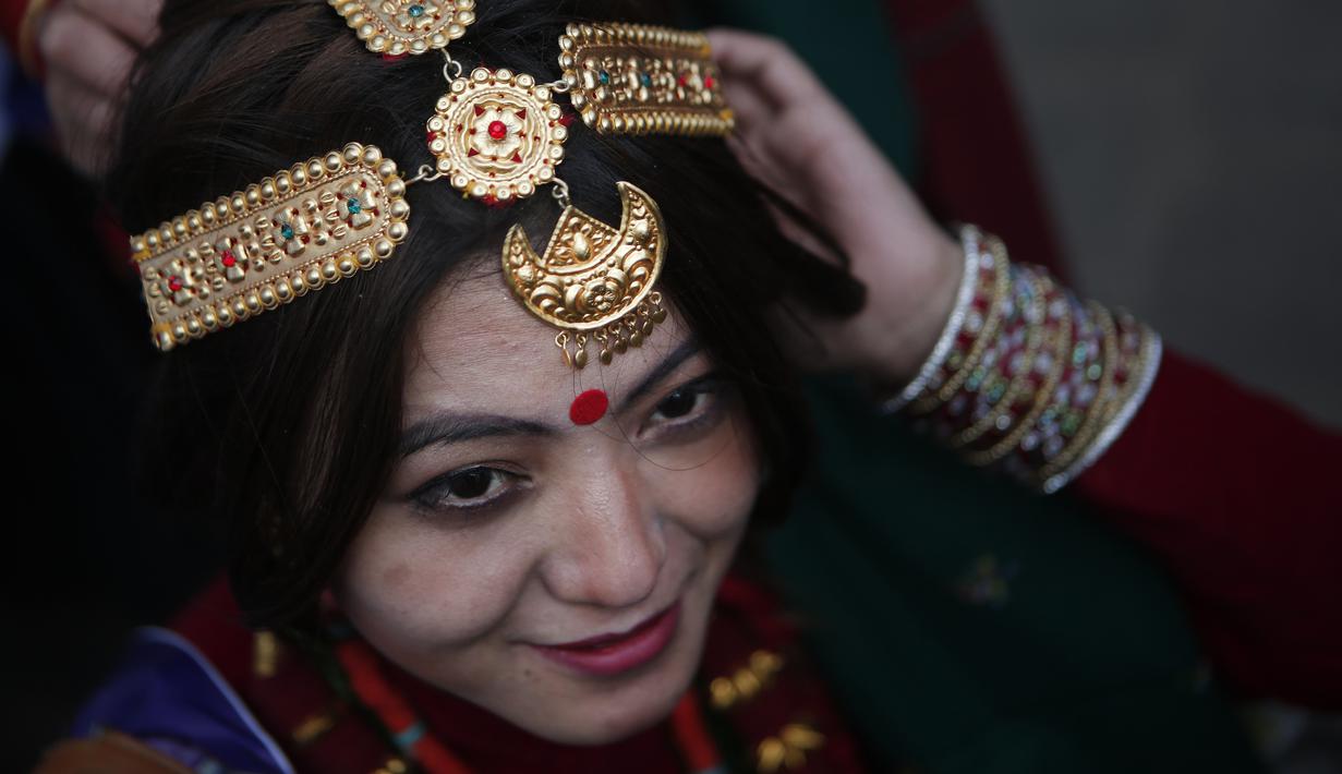 Seorang wanita memakai perhiasan jelang parade "Tamu Losar", Kathmandu, Nepal, Jumat (30/12). Parade tersebut digelar untuk menyambut pergantian tahun. (AP Photo / Niranjan Shrestha)