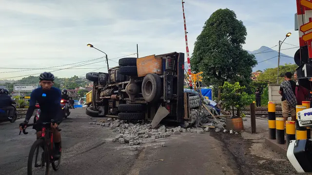 Truk terguling di pintu perlintasan kereta Batu Tulis, Kecamatan Bogor Selatan, Kota Bogor, Sabtu (14/1/2023) pagi. (Liputan6.com/Achmad Sudarno)