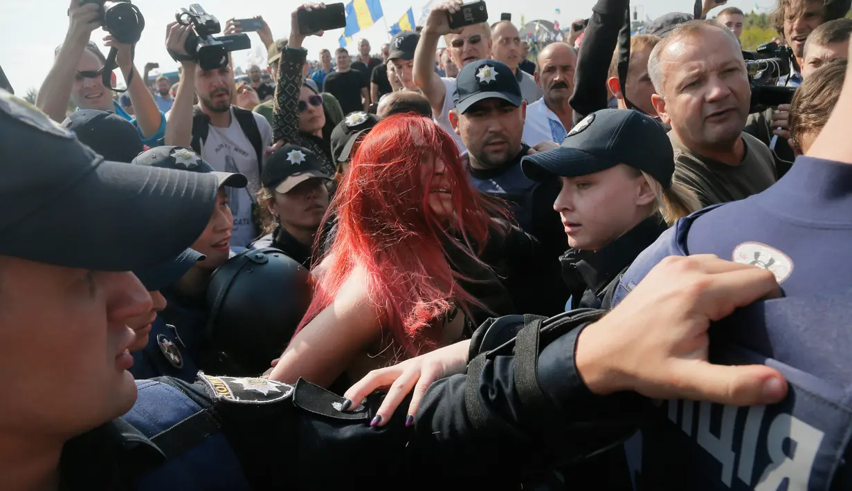 Aktivis perempuan Femen saat ditangkap polisi di titik cek Krakovets di perbatasan Ukraina-Polandia, di Ukraina, (10/9).  Aktivis ini menentang kembalinya mantan presiden Georgia Mikheil Saakashvili ke Ukraina. (AP Photo / Efrem Lukatsky)