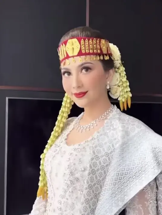 Sementara itu, Hair do ditata oleh Woko. Seperti pengantin perempuan Batak lainnya, Jessica mengenakan hiasan kepala bernama sortali. Ikat kepala ini memiliki dasar merah dengan beberapa garis berwarna emas. Ditambah dengan ronce melati dan bunga mawar putih. Credit: Instagram (@marlenehariman)