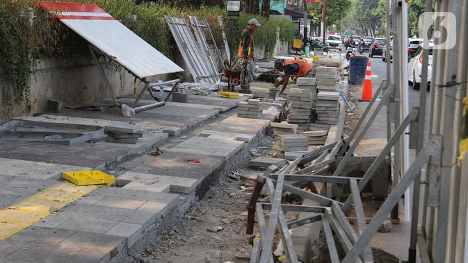 Pekerja mengerjakan proyek revitalisasi trotoar di kawasan Kemang, Jakarta Selatan, Selasa (15/10/2019). Pemerintah Provinsi DKI menargetkan pelebaran dan penataan trotoar ini akan rampung pada Desember 2019. (Liputan6.com/Herman Zakharia)