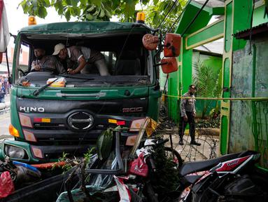 Polisi mencoba memindahkan truk setelah kecelakaan lalu lintas di Bekasi, Indonesia, Rabu (31/8/2022). Sebanyak 10 orang dilaporkan meninggal dunia dalam kecelakaan maut tersebut. (AP Photo/Achmad Ibrahim)