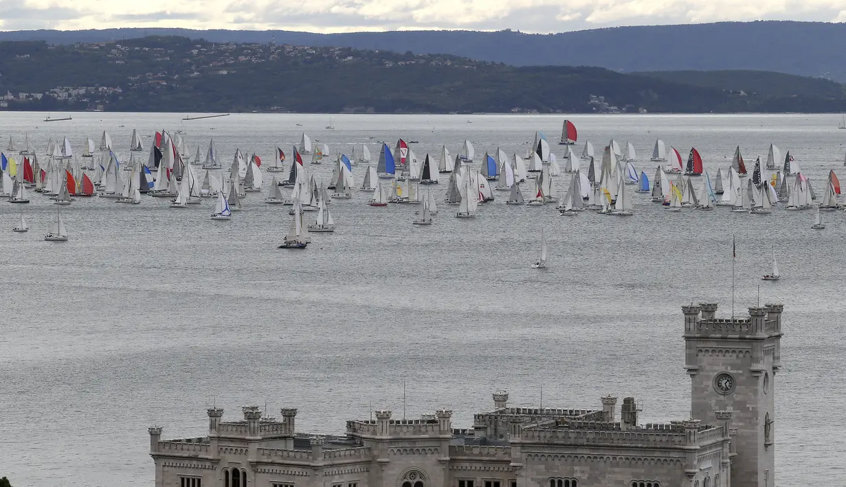 Ribuan kapal layar membentuk barisan saat perlombaan tahunan Barcolana di Pelabuhan Trieste, Italia, Minggu (11/10). Barcolana merupakan salah satu perlombaan kapal layar tahunan terbesar di dunia yang dimulai sejak 1969. (REUTERS/Stefano Rellandini)