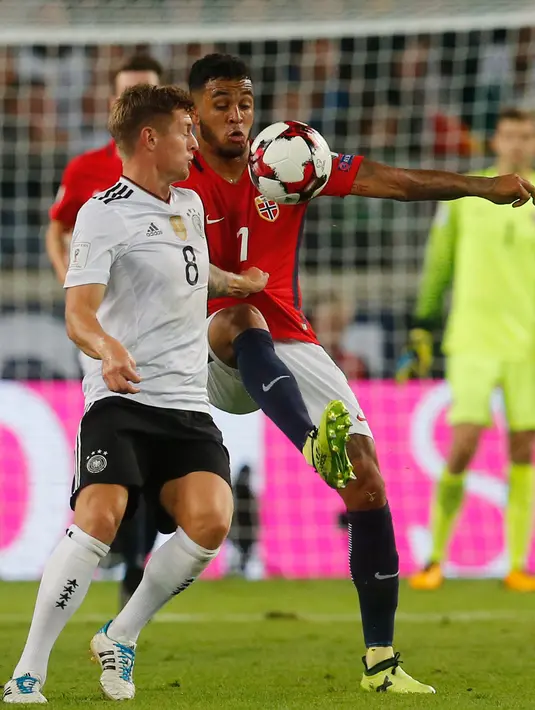 Gelandang Jerman, Toni Kroos berebut bola dengan penyerang Norwegia, Joshua King saat bertanding pada grup C Kualifikasi Piala Dunia 2018 di Stuttgart, Jerman,(4/9). Jerman menang telak atas Norwegia 6-0. (AP Photo/Matthias Schrader)
