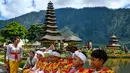 Pura Ulun Danu Beratan juga dikelilingi oleh taman hijau yang terawat rapi, menyediakan area yang nyaman untuk bersantai dan menikmati keindahan alam. Tampak dalam foto, sejumlah pemuda bersiap mengikuti prosesi keagamaan di Pura Ulun Danu Beratan, sebuah pura Hindu di Danau Beratan dekat Bedugul, Bali, pada Jumat 7 November 2025. (Mladen ANTONOV/AFP)