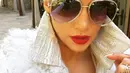 Tak sedang berada di atas panggung, Jlo tetap menampilkan kemewahannya. Kali ini tidak dengan blink-blinknya, Jlo hanya mengenakan jaket berbulu warna putih. Kacamata hitam dan bibir merahnya membuat Jlo terlihat seksi di foto tersebut. (Instagram/Jlo)
