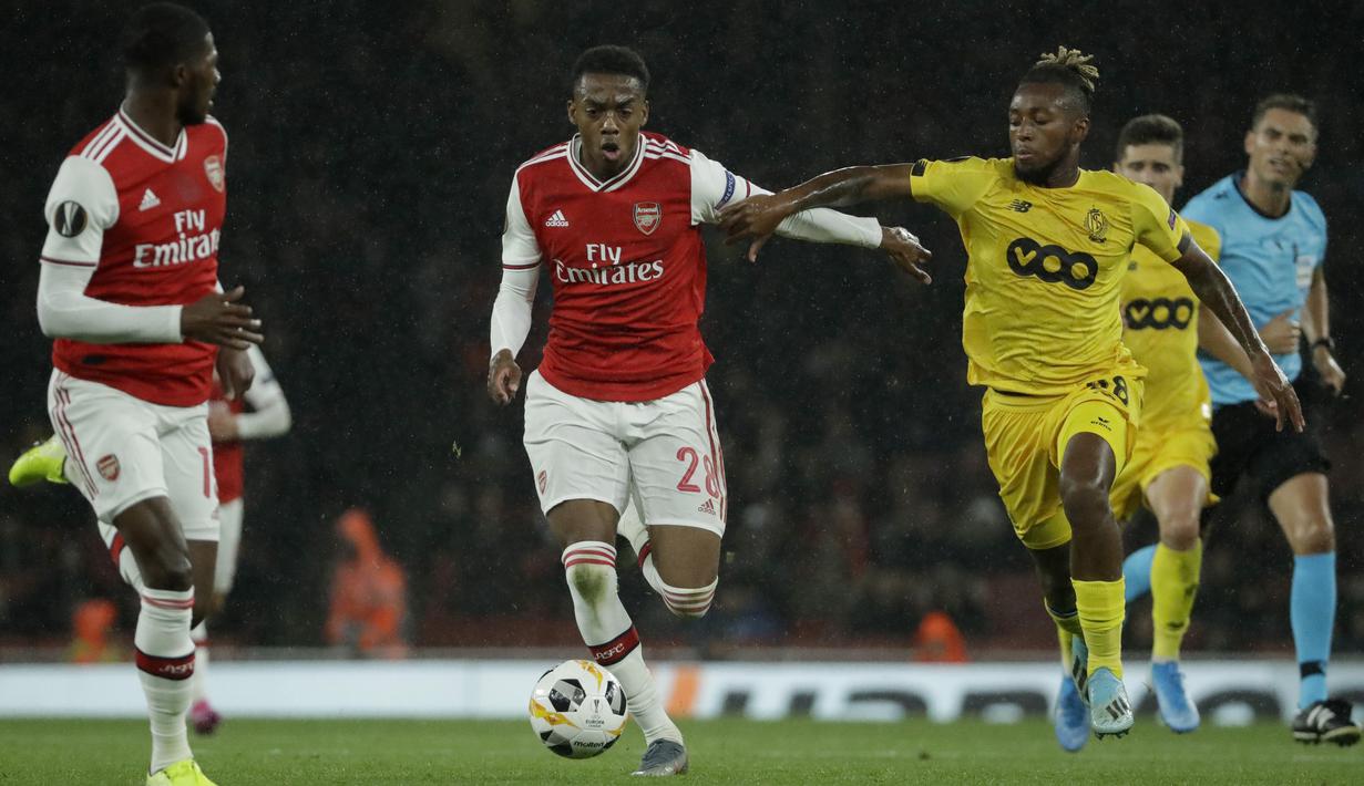 Gelandang Arsenal, Joe Willock (tengah) menggiring bola dari kawalan pemain Standard Liege, Samuel Bastien (kanan) pada lanjutan pertandingan grup F Liga Europa di Stadion Emirates, London (3/10/2019). Willock mencetak satu gol dan mengantar Arsenal menang telak 4-0. (AP Photo/Matt Dunham)