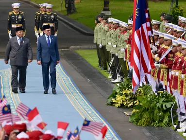 Presiden Republik Indonesia Prabowo Subianto (tengah depan) dan Perdana Menteri (PM) Malaysia Anwar Ibrahim (kanan depan) memeriksa pasukan pengawal presiden sebelum pertemuan mereka di Istana Merdeka di Jakarta pada 27 Juni 2025. (BAY ISMOYO/AFP)