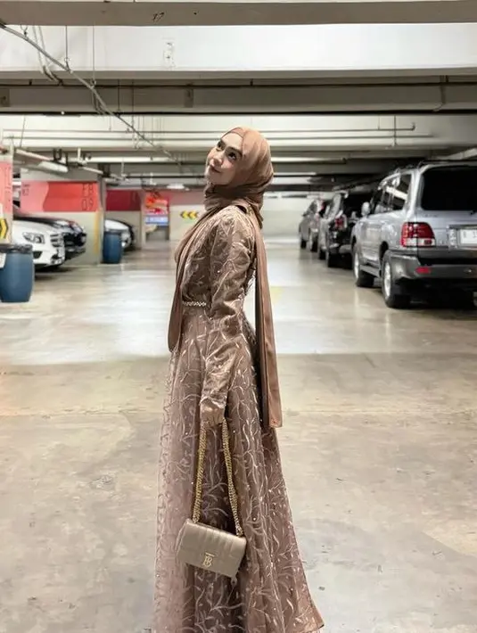 Ria Ricis memilih mengenakan dress coklat dengan aksen bordirannya. Dipadukan kerudung warna senada dan sling bagnya. [@riaricis1795]