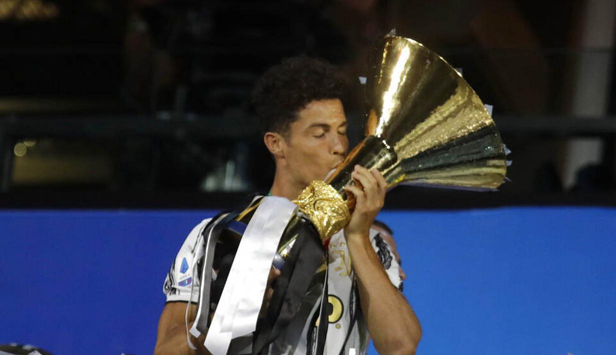 Striker Juventus, Cristiano Ronaldo, mencium trofi juara Serie A musim 2019-20 di Stadion Allianz, Sabtu (1/8/2020). CR7 berhasil membawa Juventus merengkuh gelar Liga Italia kesembilan secara beruntun. (AP Photo/Luca Bruno)