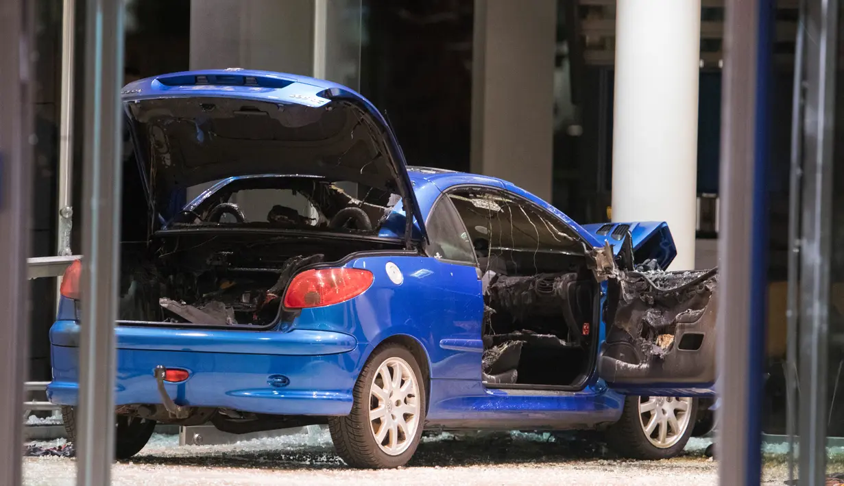 Sebuah mobil warna biru hancur setelah menabrak kantor Partai Sosial Demokratik Jerman (SPD) dengan sengaja di Berlin (25/12). Menurut keterangan pelaku pria kepada polisi, ia ingin bunuh diri. (AFP PHOTO / Ganjil Andersen)