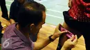 Petugas menempelkan alat deteksi di paha Tontowi Ahmad saat berlatih di pelatnas PBSI, Cipayung, Jakarta, Rabu (13/1/2016). Pebulutangkis Indonesia melakukan pematangan program latihan jelang Olimpiade 2016. (Liputan6.com/Helmi Fithriansyah)