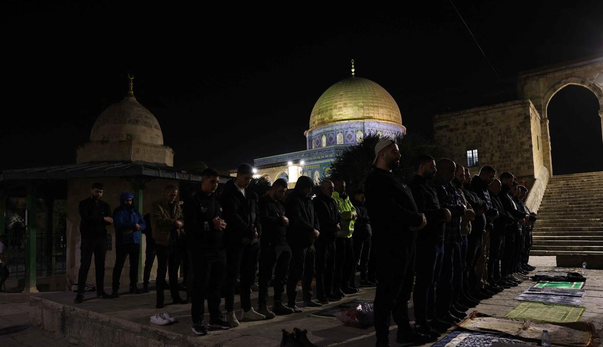 Warga Palestina melaksanakan salat Tarawih pertama di bulan suci Ramadan di kompleks Masjid Al-Aqsa, Yerusalem, pada Selasa 17 Februari 2026 malam waktu setempat. Tampak dalam foto, para jamaah Muslim Palestina melaksanakan salat Tarawih pada malam pertama bulan suci Ramadan di dekat Kubah Batu, kompleks Masjid Al-Aqsa, Kota Tua Yerusalem pada 17 Februari 2026. (AHMAD GHARABLI/AFP)