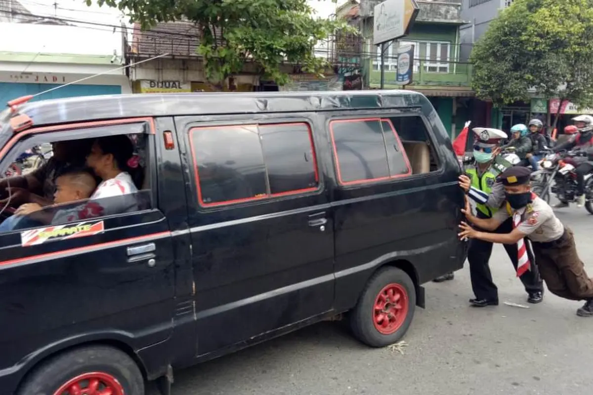 Relawan dan polisi mendorong mobil pemudik yang mogok di Gombong, Kebumen pada arus mudik lebaran 2018, Selasa, 12 Juni 2018. (Liputan6.com/Polres Kebumen/Muhamad Ridlo)