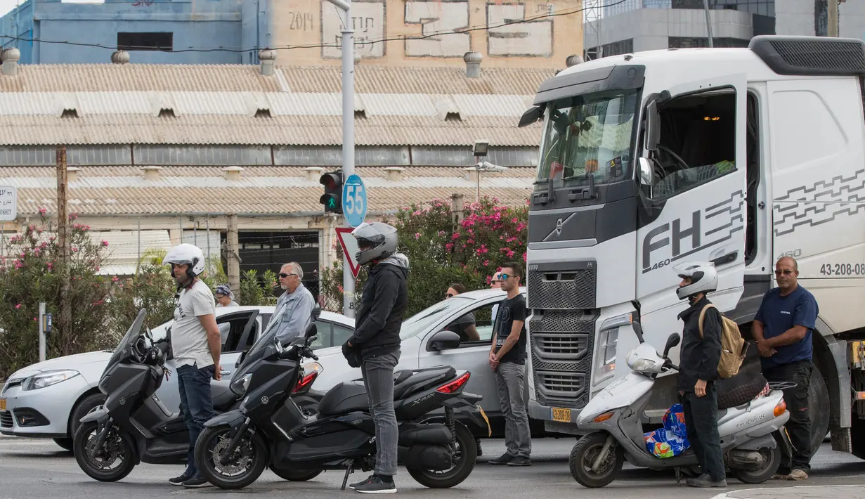 Pengendara motor mengheningkan cipta ketika sirine panjang Hari Peringatan Holocaust berbunyi di Tel Aviv, Israel (24/4). Warga Israel mengenang peristiwa pembantaian terhadap enam juta umat Yahudi oleh Nazi selama Perang Dunia II. (AFP Foto/Jack Guez)