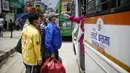 Seorang staf mengukur suhu tubuh penumpang bus di Kathmandu (16/7/2020). Beberapa perusahaan angkutan umum di Lembah Kathmandu mulai mengoperasikan kembali rute mereka untuk pertama kalinya dalam hampir empat bulan setelah menerima persyaratan operasional dari pemerintah. (Xinhua/Sulav Shrestha)