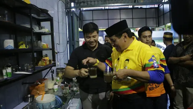 Cagub Sulsel, Nurdin Halid berlagak sebagai peracik kopi melayani pengunjung salah satu warkop di Kabupaten Soppeng, Sulsel (Liputan6.com/ Eka Hakim)