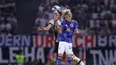Pemain Timnas Jepang, Junya Ito (kanan), melakukan duel udara dengan pemain Timnas Jerman, Robin Gosens, dalam pertandingan persahabatan yang berlangsung di Volkswagen Arena, Wolfsburg, Minggu (10/9/2023). (AFP/Ronny Hartmann)