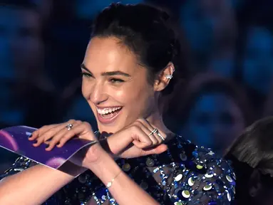  Aktris Gal Gadot tersenyum saat menjadi host pada ajang penghargaan MTV Video Music Awards (VMA) 2017 di Inglewood, California, AS (27/8). Pemeran Wonder Woman ini tampil cantik mengenakan gaun biru transparan. (Photo by Chris Pizzello/Invision/AP)