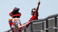 Pembalap Repsol Honda, Marc Marquez memanjat pagar lintasan setelah berhasil finis pertama pada balapan MotoGP Spanyol 2018 di Sirkuit Jerez, Minggu (6/5). Marquez mengukir waktu 41 menit 39,678 detik. (AP Photo/Miguel Morenatti)