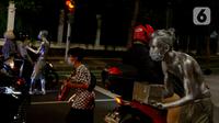 Manusia silver saat menghibur pengendara bermotor di perempatan kawasan Senayan, Jakarta, Sabtu (9/5/2020). Meskipun di tengah pandemi Covid-19, para manusia silver ini masih tetap melakukan aksinya di jalanan untuk memenuhi kebutuhan sehari-hari. (merdeka.com/Imam Buhori)
