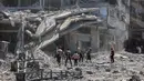 Warga Palestina mencari barang-barang yang dapat diselamatkan di reruntuhan bangunan yang hancur sehari sebelumnya dalam serangan Israel di lingkungan Al-Daraj, Kota Gaza pada 16 Juli 2025. (Omar AL-QATTAA/AFP)