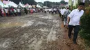 Pengunjung menghindari jalan yang becek pada Festival Lebaran Betawi IX, Jakarta, (14/8). Festival diramaikan dengan rumah adat Betawi dari masing-masing pemkot  administrasi Jakarta serta Kabupaten Kepulauan Seribu. (Liputan6.com/Immanuel Antonius)