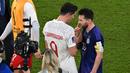 Dalam laga sebelumnya, tepatnya pada matchday pamungkas Grup C saat Polandia kalah 0-2 dari Argentina (1/12/2022), Robert Lewandowski juga kedapatan berbisik dengan Lionel Messi yang notabene juga merupakan pemain yang kini membela PSG. (AFP/Glyn Kirk)