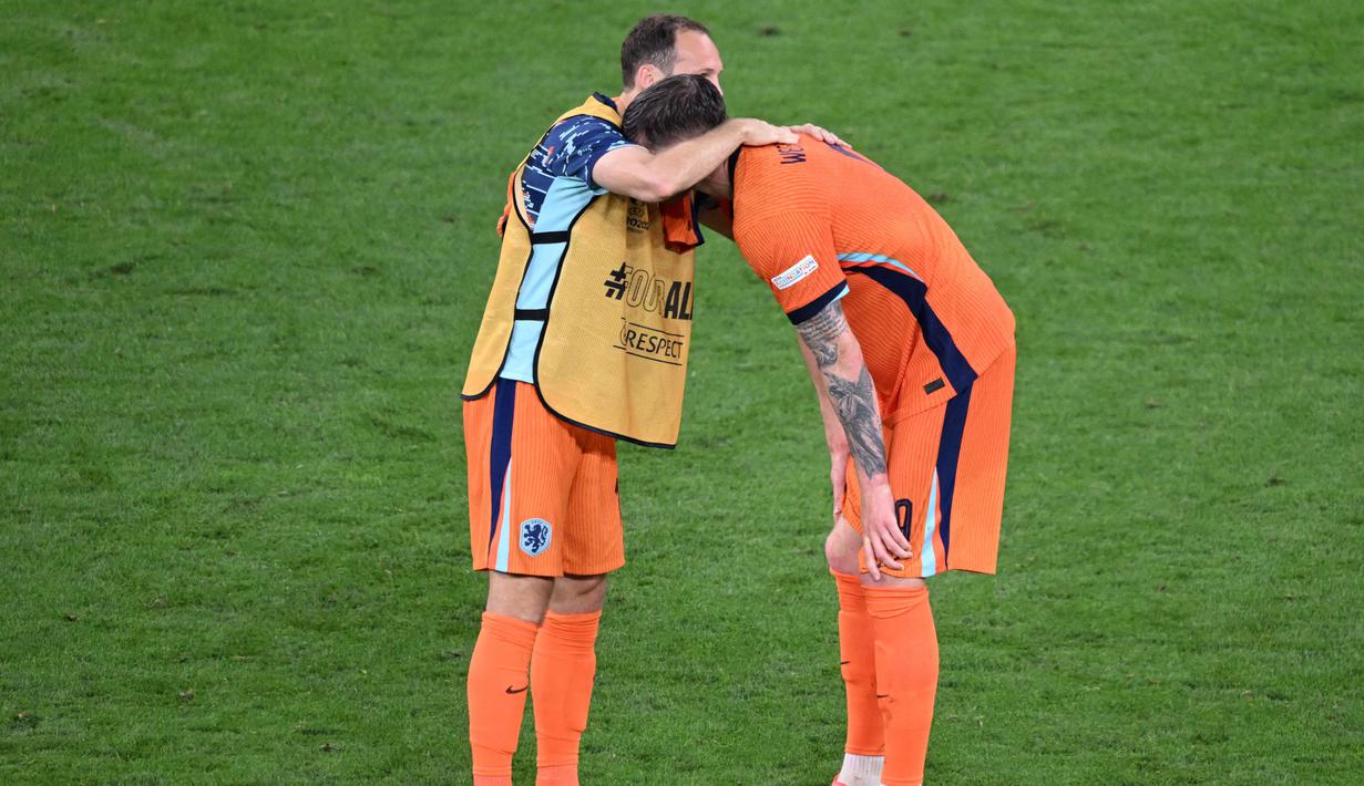 Pemain Belanda, Daley Blind, berusaha menenangkan Wout Weghorst yang kecewa berat setelah ditaklukkan Inggris. Timnas Pusat tumbang dengan skor 1-2. (AFP/Kirill Kudryavtsev)