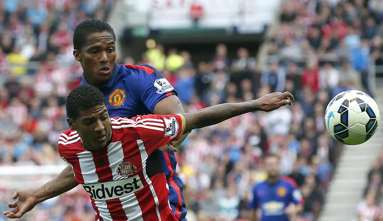 Gelandang Manchester United, Antonio Valencia (belakang), berebut bola dengan pemain belakang Sunderland, Patrick van Aanholt, di laga lanjutan Liga Primer Inggris di Stadium of Light, (24/8/2014). (REUTERS/Andrew Yates)