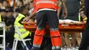 Ia pun kemudian mendapatkan pertolongan medis sembari ditandu ke luar lapangan pertandingan. Carvajal dipastikan mengalami cedera lutut ligamen ACL yang serius. (AFP/Oscar Del Pozo)