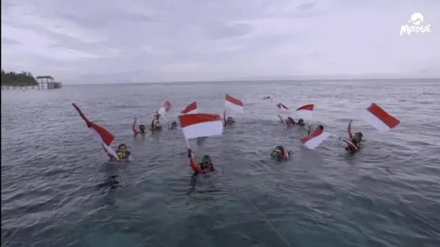 Potret Ketua TP-PKK Morotai Pimpin Pengibaran Bendera Merah Putih di dalam Laut