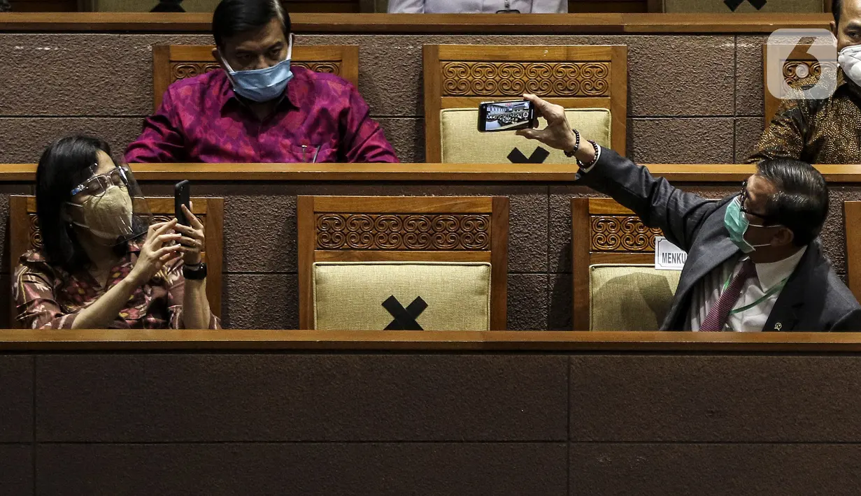 Menteri Keuangan Sri Mulyani (kiri) bersama Menteri Hukum dan HAM Yasonna Laoly (kanan) saat mengikuti Rapat Paripurna di Kompleks Parlemen, Jakarta (5/10/2020).Rapat membahas berbagai agenda, salah satunya mengesahkan RUU Omnibus Law Cipta Kerja menjadi UU. (Liputan6.com/JohanTallo)