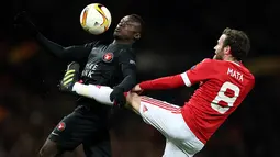 Pemain Midtjylland, Pione Sisto, berebut bola dengan gelandang Manchester United, Juan Mata. Meski pada leg pertama MU takluk 1-2, namun berhasil lolos karena menang 5-1 di kandang. (EPA/Nigel Roddis)