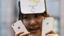 Seorang wanita asal Jepang menunjukkan iPhone 6s di Apple Store di pusat perbelanjaan, Tokyo, Jepang (25/9/2015). iPhone 6s dibandrol dengan harga sekitar 12 juta - 15 juta rupiah, sedangkan 6s Plus 13 juta - 17 juta rupiah. (REUTERS/Issei Kato) 