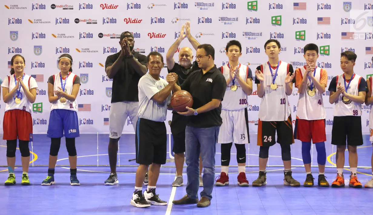 Gubernur DKI Jakarta Anies Baswedan memberikan penghargaan Teacher of the Year kepada Johan Latupapua pada Jr. NBA Indonesia Camp 2019 di Cilandak, Jakarta, Minggu (31/3). Anies mengapresiasi inisiatif dari Jr. NBA Asia yang telah mendukung dan mengawasi para guru. (Liputan6.com/Fery Pradolo)