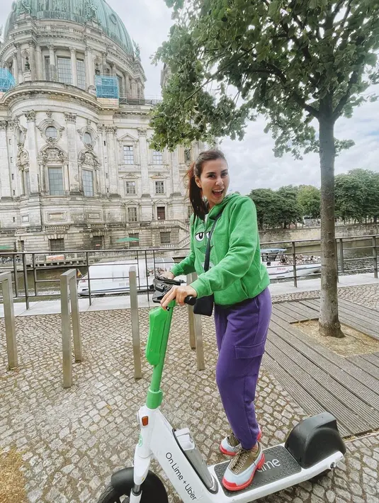 Mengenakan skuter, Syahnaz tampak ceria berjalan mengelilingi Jerman. Kali ini ia tampil kasual dengan hoodie berwarna hijau yang dipadukan dengan celana berwarna biru.(Liputan6.com/IG/@syahnazs)