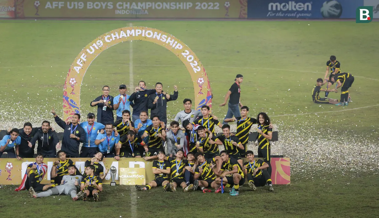 Pemain Timnas Malaysia U-19, Adam Farhan Mohd Faizal (kanan ketiga) berusaha ditolong oleh sejumlah rekannya saat timnya merayakan juara Piala AFF U-19 2022 di Stadion Patriot Candrabhaga, Bekasi, Jumat (15/07/2022). (Bola.com/Bagaskara Lazuardi)