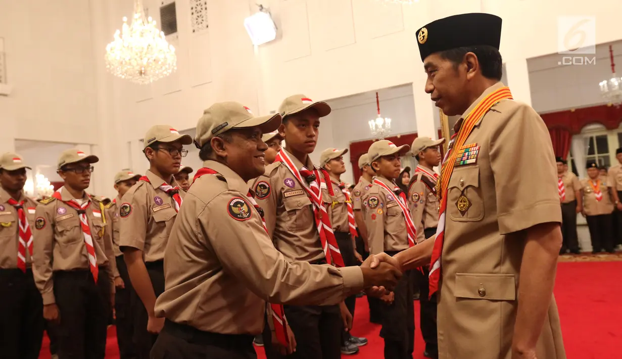 Presiden Joko Widodo (kanan) menyalami Kontingen Gerakan Pramuka Indonesia saat upacara pelepasan di Istana Negara, Jakarta, Jumat (19/7/2019). Kontingen Gerakan Pramuka Indonesia mengirimkan 67 peserta untuk menghadiri Jambore Pramuka Dunia XXIV. (Liputan6.com/Angga Yuniar)