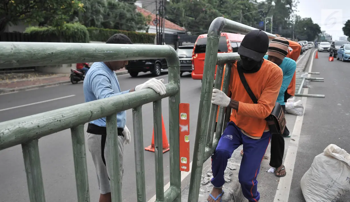 Pekerja dari Dinas Perhubungan DKI Jakarta melakukan pemasangan pagar pembatas jalan di Jalan HOS. Cokroaminoto, Jakarta, Selasa (6/11). Pemasangan pagar bertujuan mencegah pejalan kaki menyeberang sembarangan. (Merdeka.com/ Iqbal S. Nugroho)