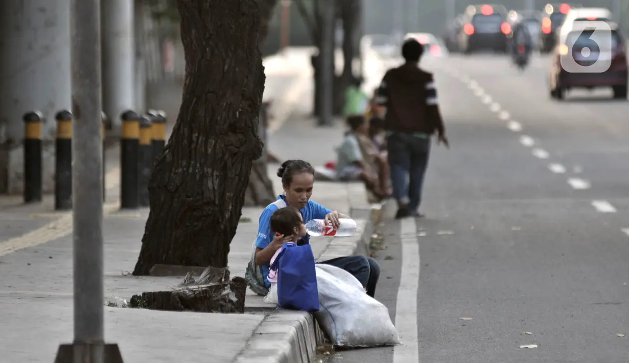 Penyandang Masalah Kesejahteraan Sosial (PMKS) menunggu warga memberikan sedekah di pinggir jalan, Jakarta, Rabu (13/5/2020). Demi memenuhi kebutuhan sehari-hari terlebih untuk Lebaran, mereka rela kejar-kejaran dengan petugas saat dirazia. (merdeka.com/Iqbal S. Nugroho)