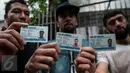Sejumlah pengungsi atau pencari suaka asal Afghanistan menunjukan kartu tanda pengungsi di depan kantor UNHCR, Jakarta, Senin (6/2). Mereka menggelar demonstrasi untuk mendesak UNCHR mempercepat proses suaka. (Liputan6.com/Gempur M Surya)