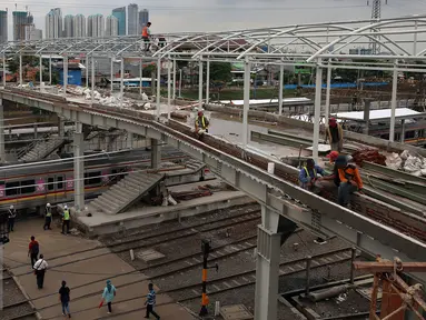 Aktivitas pekerja saat pembangunan jembatan penyeberangan orang (JPO) di Stasiun Kereta Api Tanah Abang, Jakarta, Senin (17/10). Pembangunan JPO tersebut untuk memberi rasa aman dan nyaman bagi pengguna jasa kereta api. (Liputan6.com/Johan Tallo)